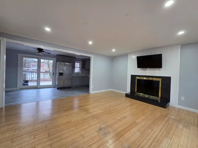 a view of an empty room with a fireplace and a window
