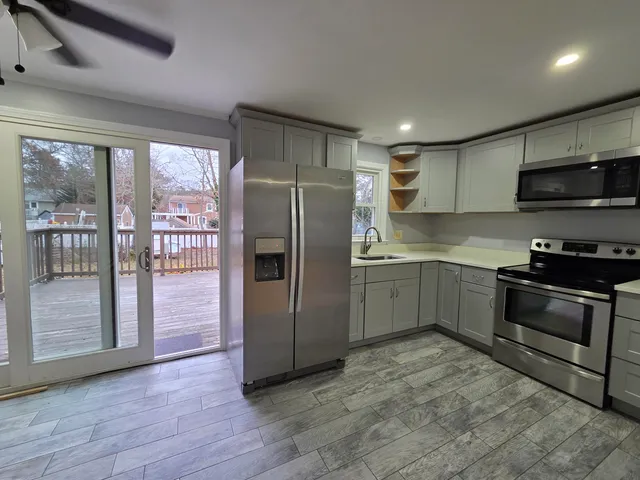 a kitchen with granite countertop a refrigerator and a stove top oven