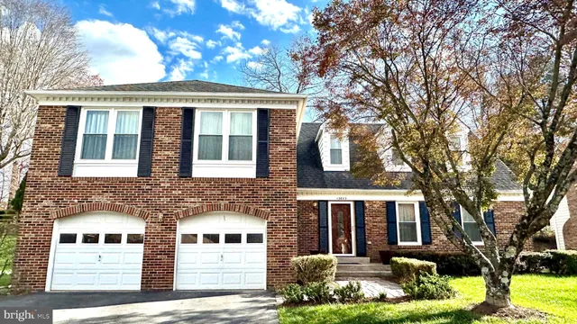 a front view of a house with yard garage and tree