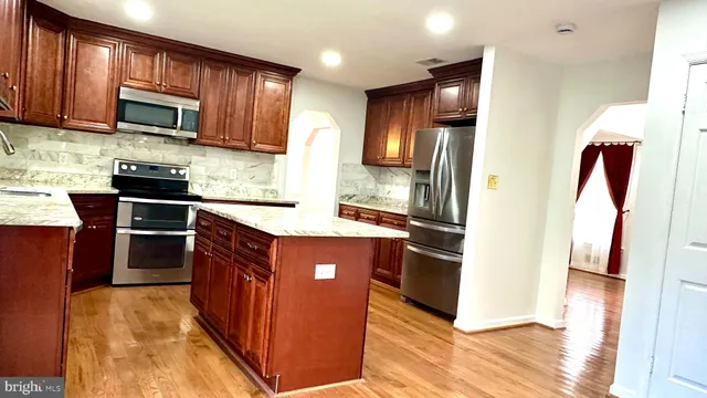 a view of empty room with wooden floor and fireplace