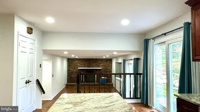 a view of a livingroom with a chandelier fan and wooden floor