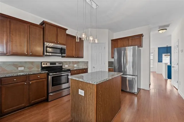 a kitchen with stainless steel appliances granite countertop a refrigerator stove and sink
