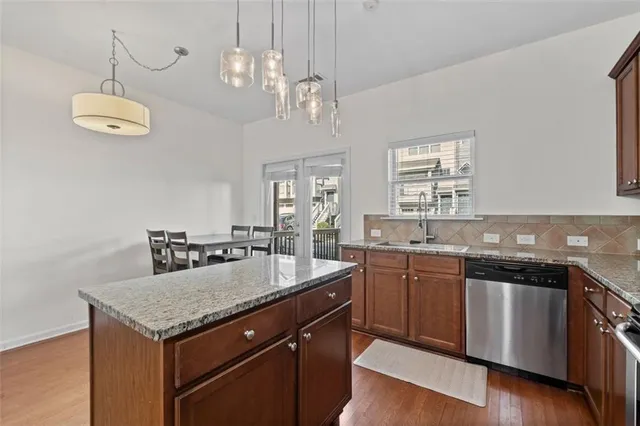 a kitchen with granite countertop cabinets a sink and stainless steel appliances