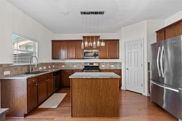 a kitchen with stainless steel appliances granite countertop a sink stove and refrigerator