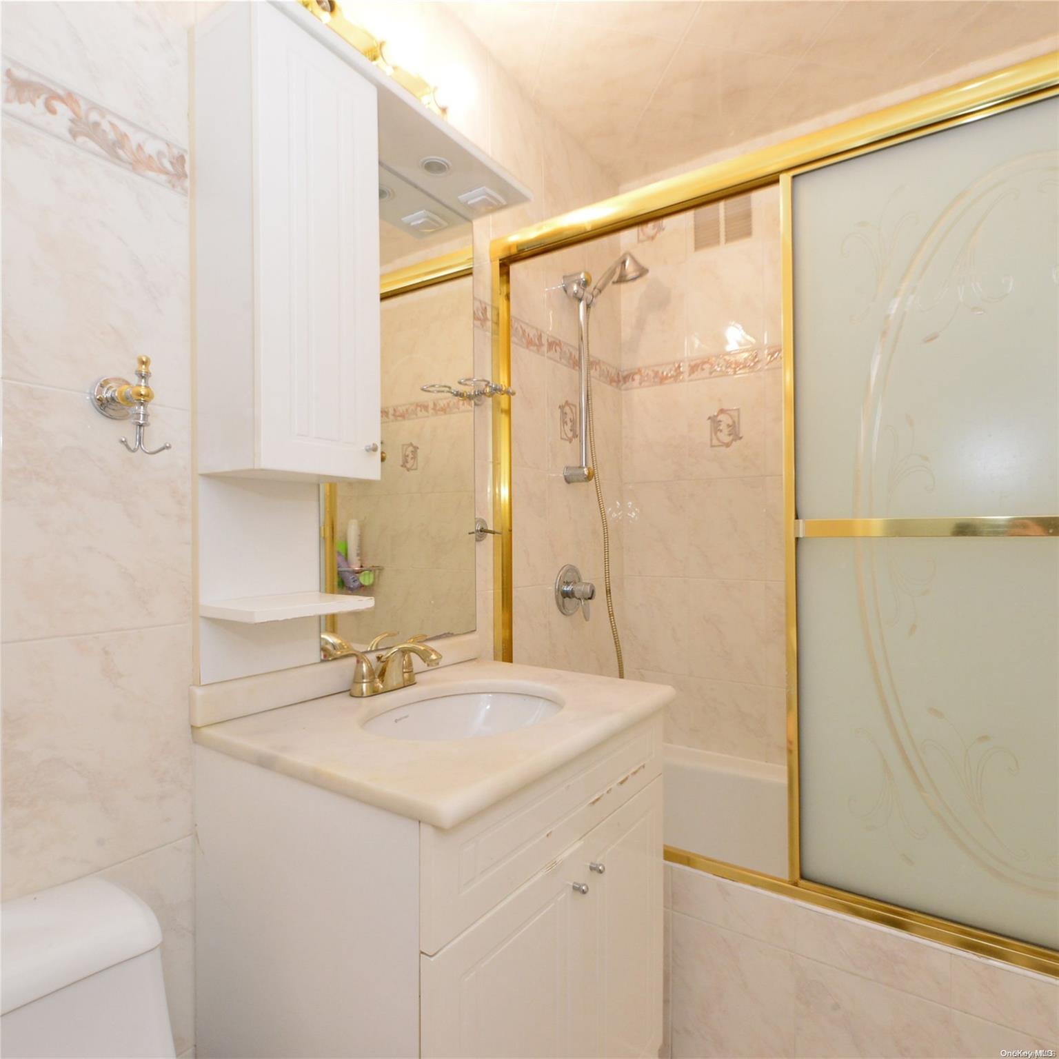 99-15 66th Avenue, Unit 4C Queens, NY 11374 - Photo 14 of 15 a bathroom with a sink a mirror and a shower