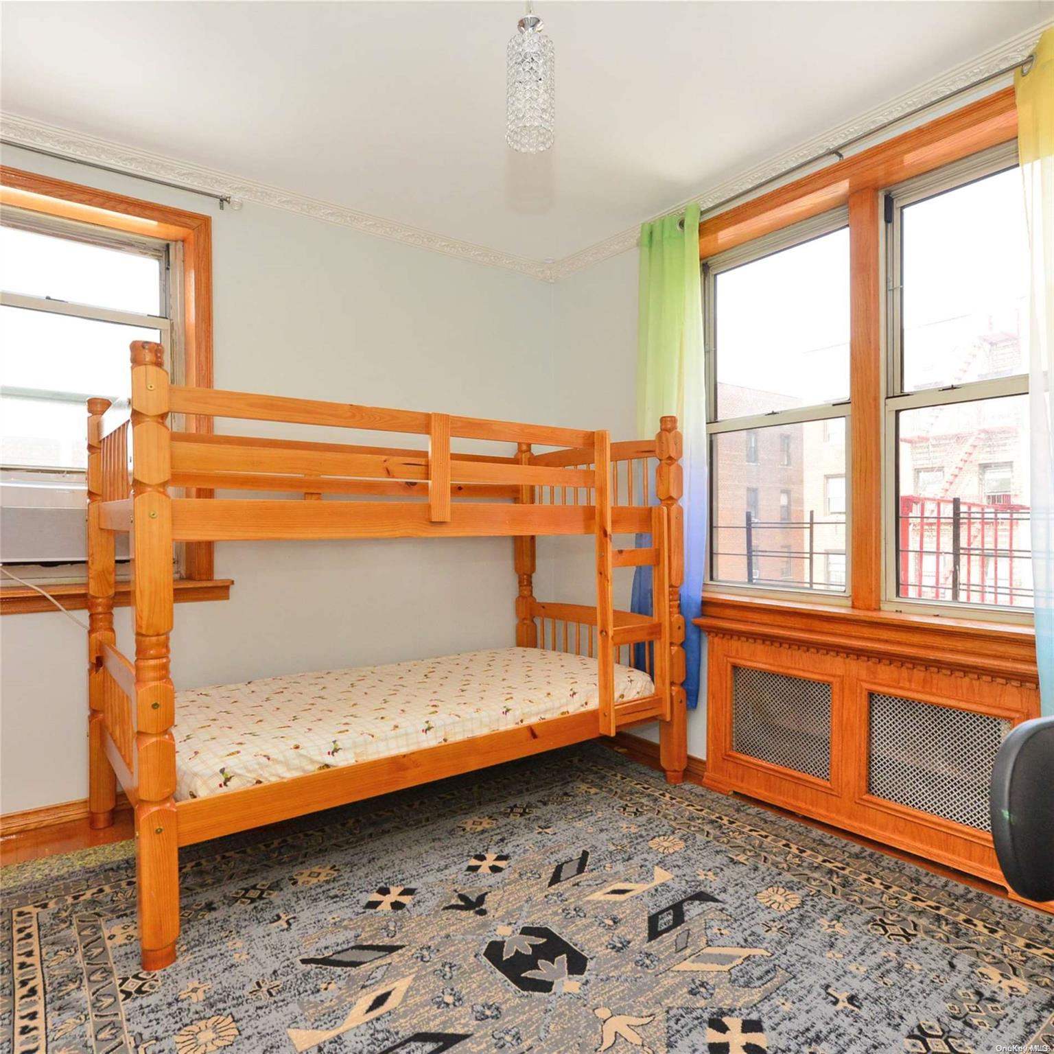 99-15 66th Avenue, Unit 4C Queens, NY 11374 - Photo 8 of 15 a bedroom with a bed and a window