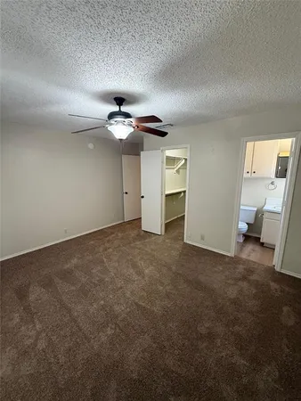 an empty room with a ceiling fan and window