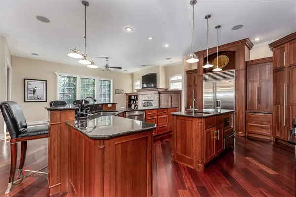 a kitchen with stainless steel appliances granite countertop a sink a stove and a wooden floors