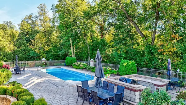 a view of a house with backyard sitting area and swimming pool