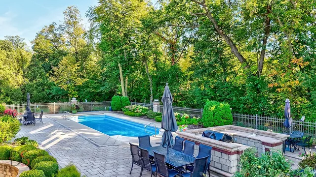 a view of a house with backyard sitting area and swimming pool