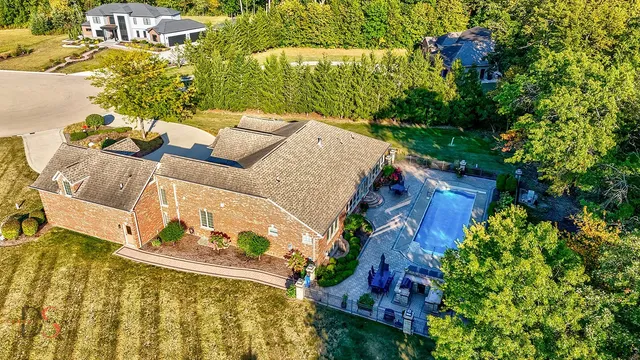 an aerial view of a house with a yard basket ball court and outdoor seating