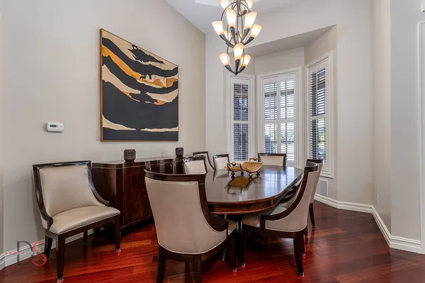 a dining room with furniture a chandelier and wooden floor