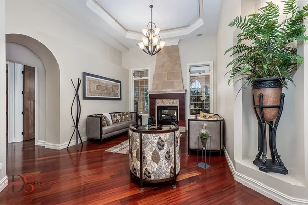 a living room with furniture a fireplace and a potted plant