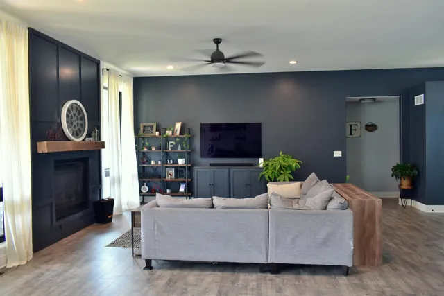 a living room with furniture a fireplace and wooden floor