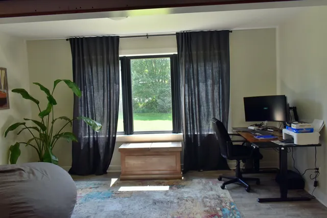 a livingroom with workspace and a window