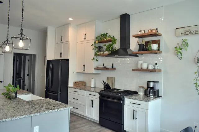 a kitchen with stainless steel appliances granite countertop a sink and a refrigerator