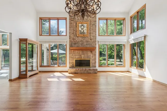 a view of livingroom with furniture wooden floor fire place and windows