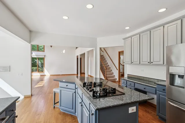 a kitchen with granite countertop white cabinets and stainless steel appliances