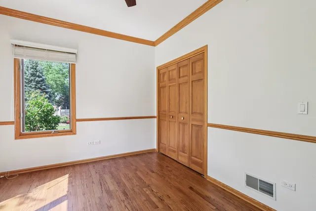 an empty room with closet and windows