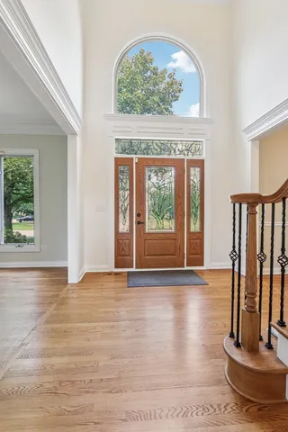 a view of a hallway with wooden floor and staircase