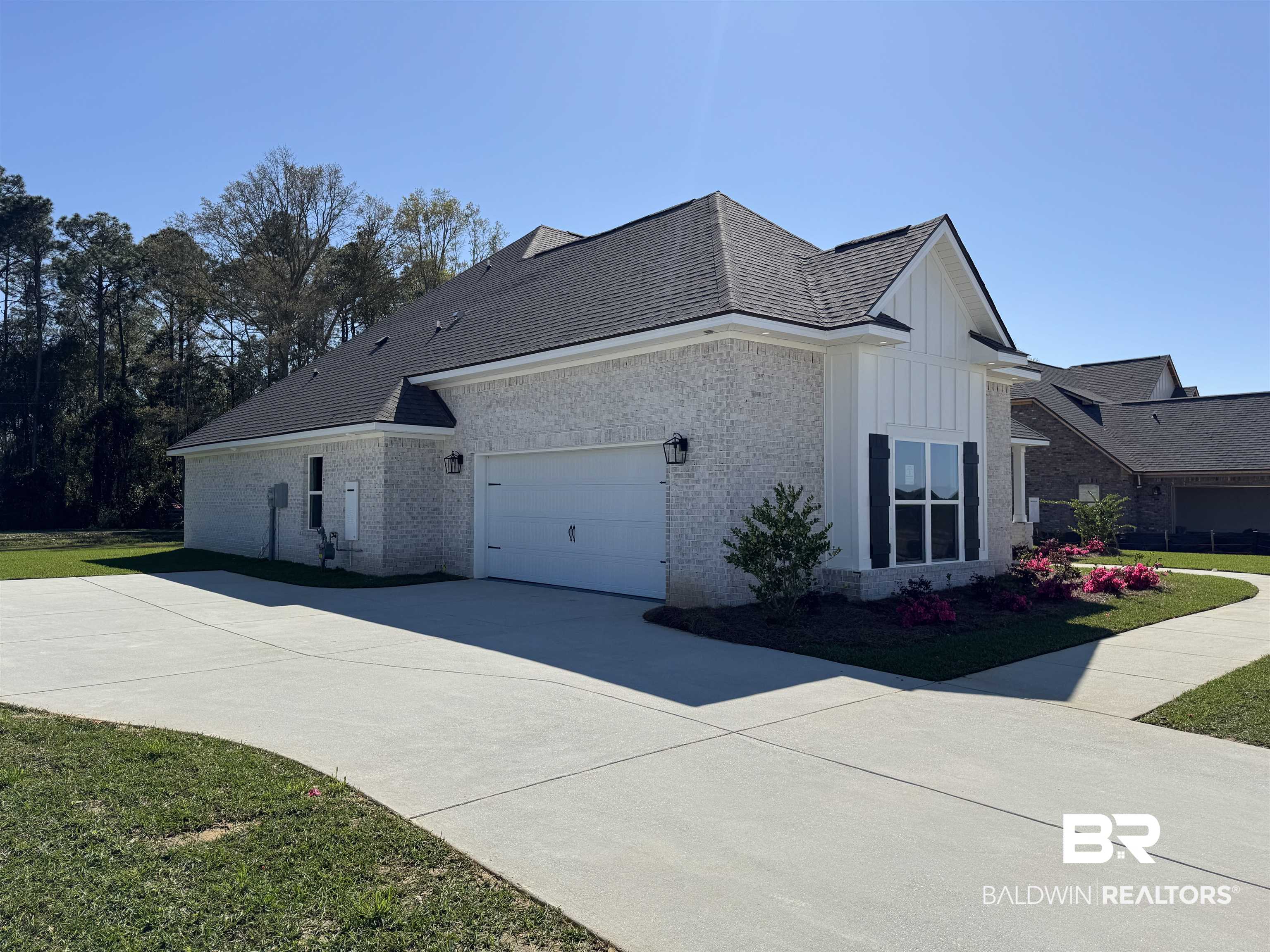 302 Morning Mist Way Fairhope, AL 36532 - Photo 3 of 33 View of property exterior featuring a yard, board and batten siding, concrete driveway, a garage, and brick siding