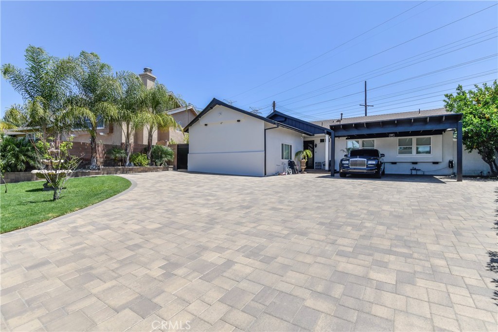 9728 Rhea Avenue Northridge, CA 91324 - Photo 4 of 36 a view of a white house with a yard and palm trees