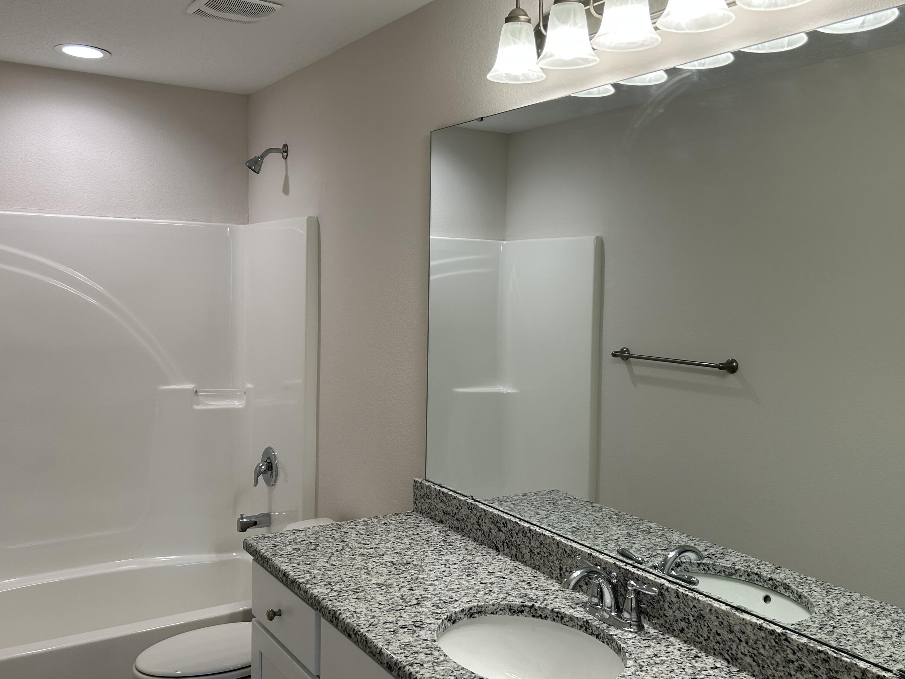 6615 Angle Road, Unit HBTS 5112 Navarre, FL 32566 - Photo 13 of 36 a bathroom with a granite countertop sink mirror vanity and toilet