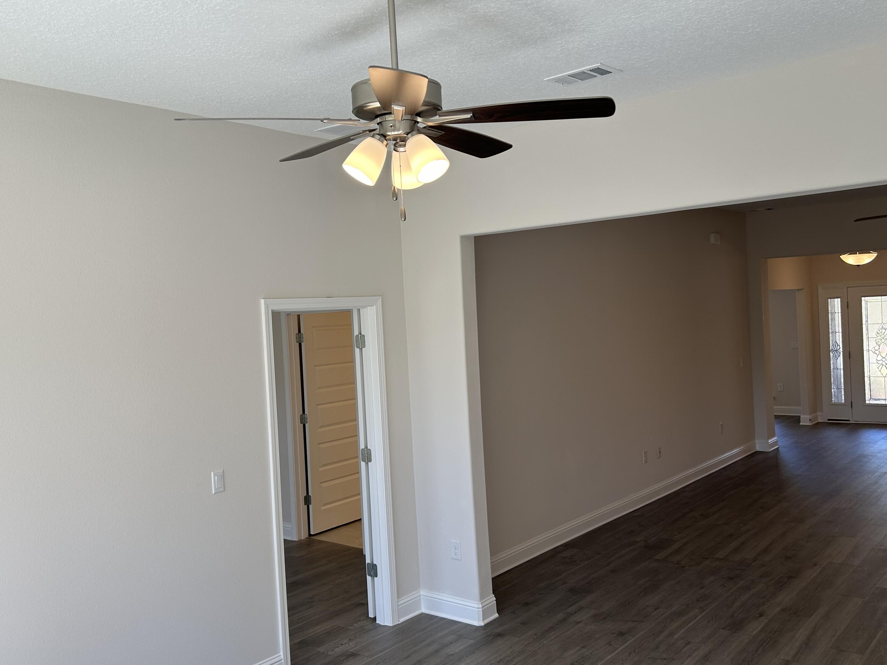 6615 Angle Road, Unit HBTS 5112 Navarre, FL 32566 - Photo 23 of 36 a view of a room with wooden floor and ceiling fan
