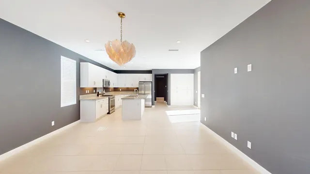 a view of open kitchen with white cabinets and refrigerator