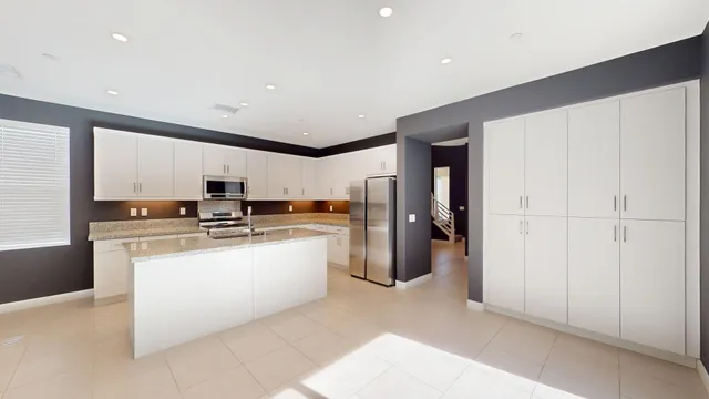 a kitchen with stainless steel appliances a refrigerator and a stove top oven
