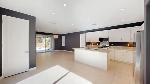 a kitchen with stainless steel appliances granite countertop a sink dishwasher a stove and white cabinets with wooden floor