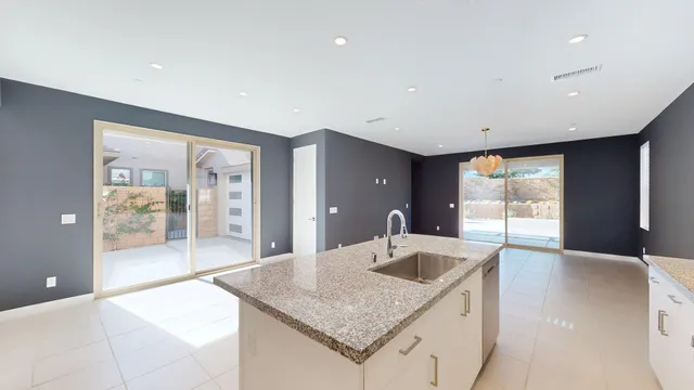 a kitchen with granite countertop a sink and a refrigerator