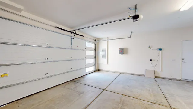 a view of a white house with a large windows and plants