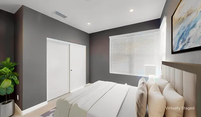 a bedroom with a bed and a potted plant