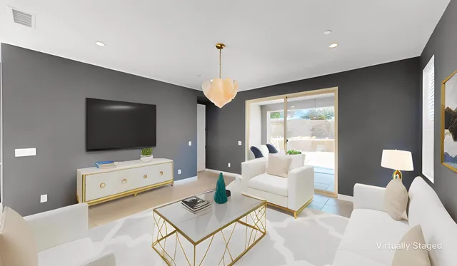 a living room with furniture a flat screen tv and a window