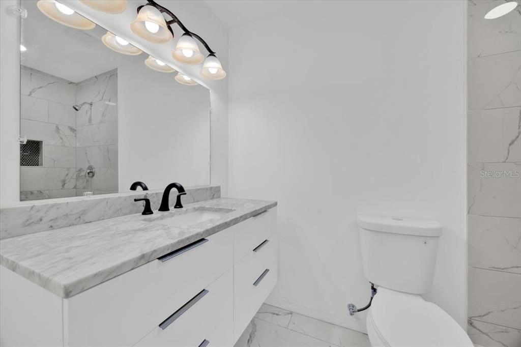 2930 Rio Lane Orlando, FL 32805 - Photo 19 of 28 a bathroom with a granite countertop sink a toilet and a mirror