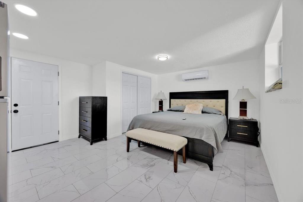 2930 Rio Lane Orlando, FL 32805 - Photo 22 of 28 a spacious bedroom with a bed and a refrigerator