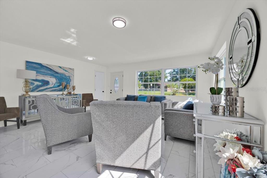 2930 Rio Lane Orlando, FL 32805 - Photo 7 of 28 a living room with furniture a fireplace and a floor to ceiling window