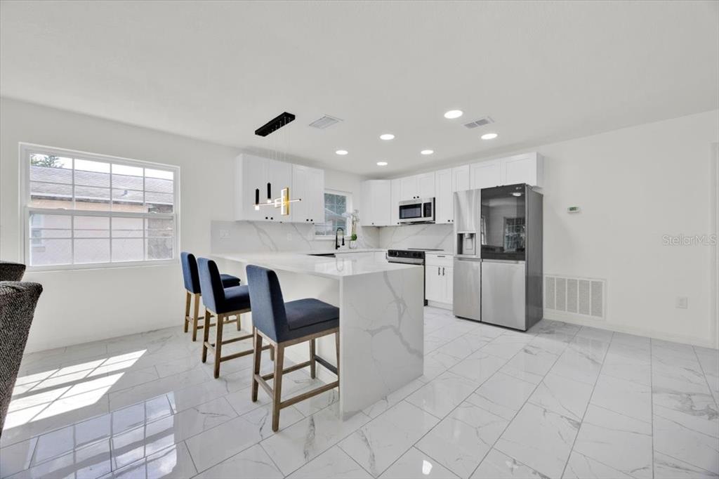 2930 Rio Lane Orlando, FL 32805 - Photo 8 of 28 a kitchen with white cabinets and dining table chair