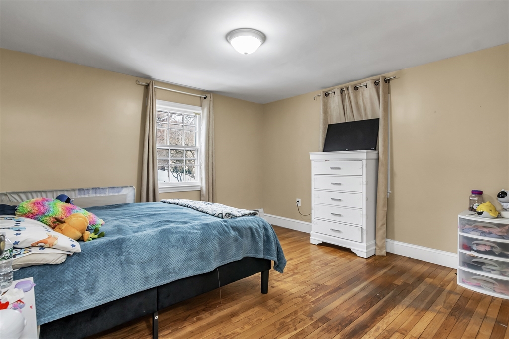 396 Oak Street Methuen, MA 01844 - Photo 12 of 42 a bedroom with a bed and wooden floor
