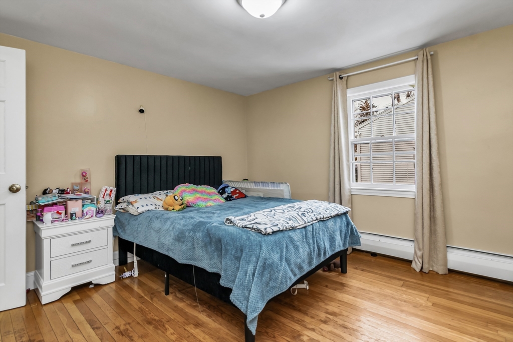 396 Oak Street Methuen, MA 01844 - Photo 13 of 42 a bedroom with a bed and wooden floor