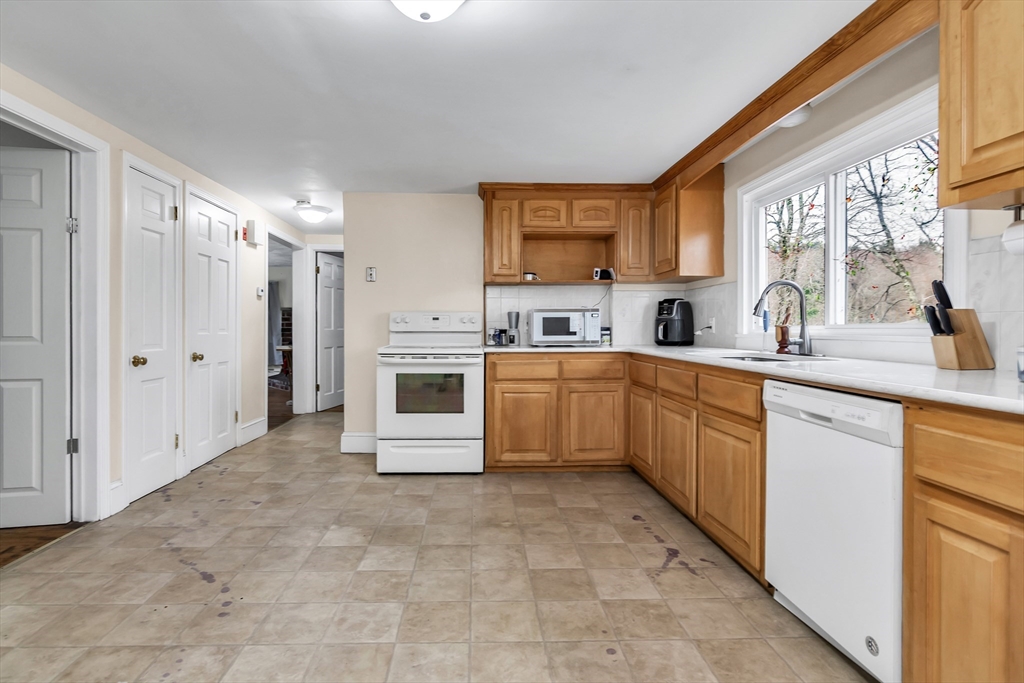 396 Oak Street Methuen, MA 01844 - Photo 9 of 42 a large white kitchen with a sink and cabinets