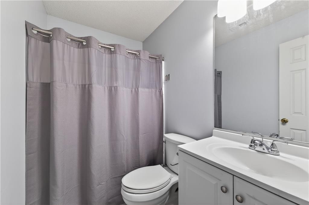 3904 Keystone Ridge Acworth, GA 30101 - Photo 19 of 45 a bathroom with a sink a toilet a mirror and shower curtain
