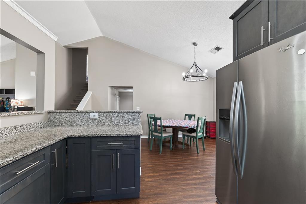 3904 Keystone Ridge Acworth, GA 30101 - Photo 32 of 45 a kitchen with stainless steel appliances granite countertop a refrigerator a stove a sink and a dining table