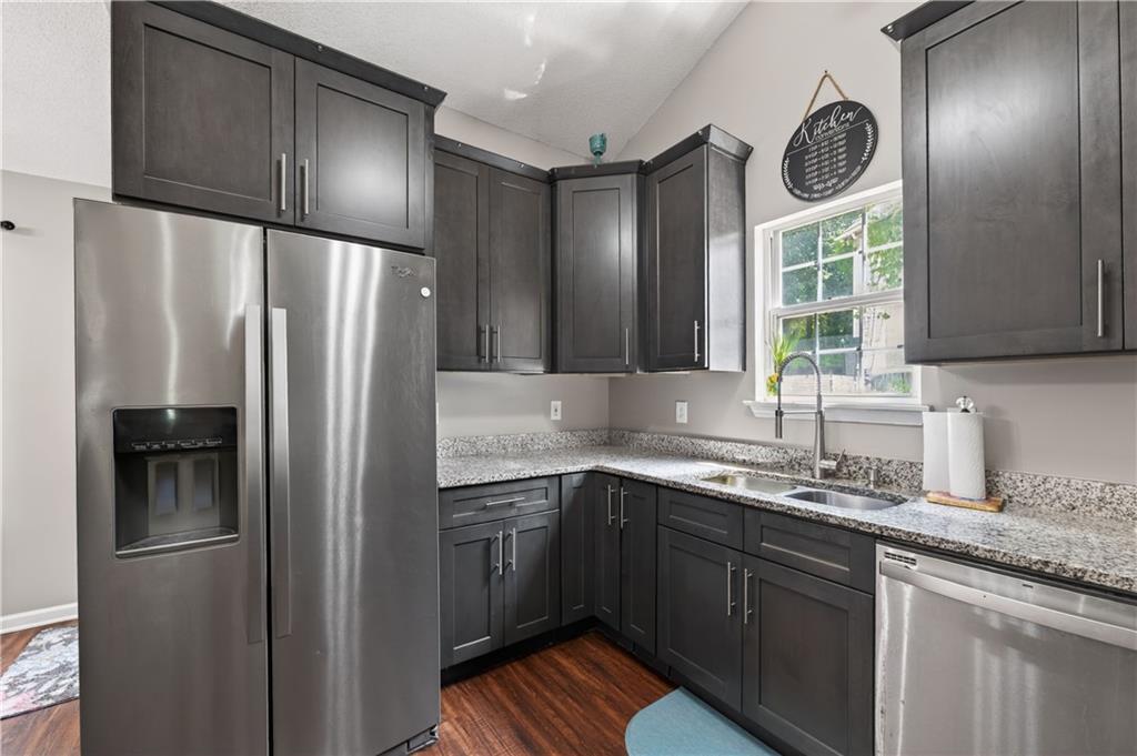 3904 Keystone Ridge Acworth, GA 30101 - Photo 33 of 45 a kitchen with stainless steel appliances granite countertop a refrigerator a sink and a refrigerator