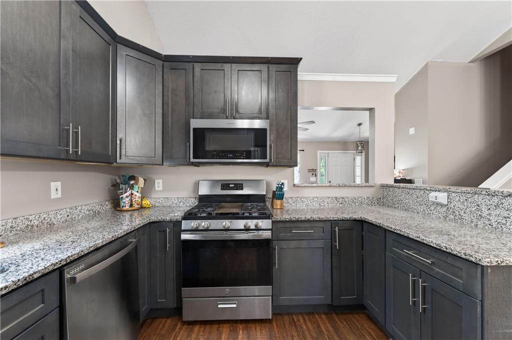3904 Keystone Ridge Acworth, GA 30101 - Photo 34 of 45 a kitchen with stainless steel appliances granite countertop a stove a sink and a microwave