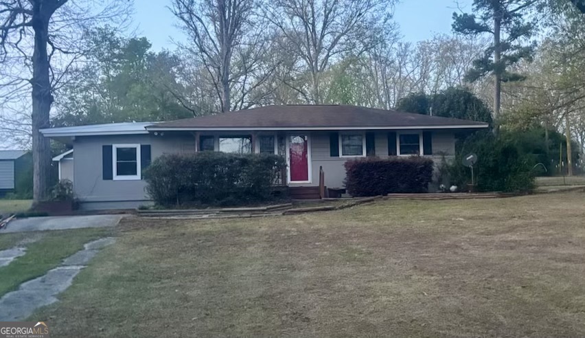 front view of a house with a yard and potted plants