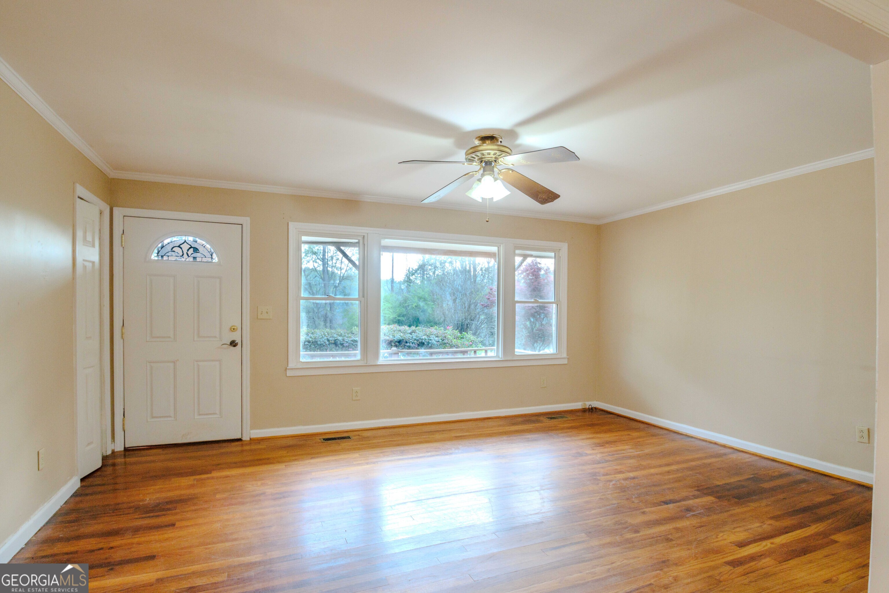 239 Hendry Lane Washington, GA 30673 - Photo 5 of 31 a view of an empty room with wooden floor and a window