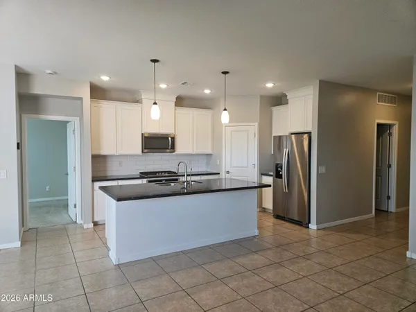 a kitchen with stainless steel appliances granite countertop a refrigerator a sink and a oven