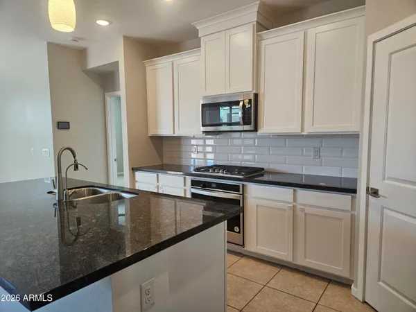 a kitchen with stainless steel appliances granite countertop a sink a stove and a microwave